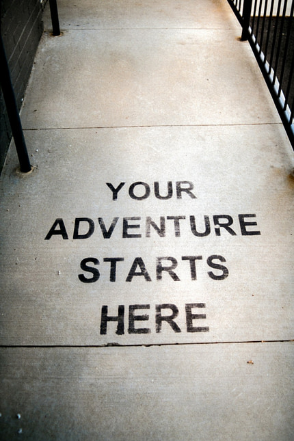 Your adventure starts here painted on sidewalk.